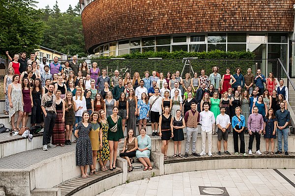 Die Alumni der Hochschule für nachhaltige Entwicklung Eberswalde stehen im Amphitheater auf der Abschlussfeier im Jahr 2022 vor dem Pfeil Auditorium am Waldcampus der HNEE